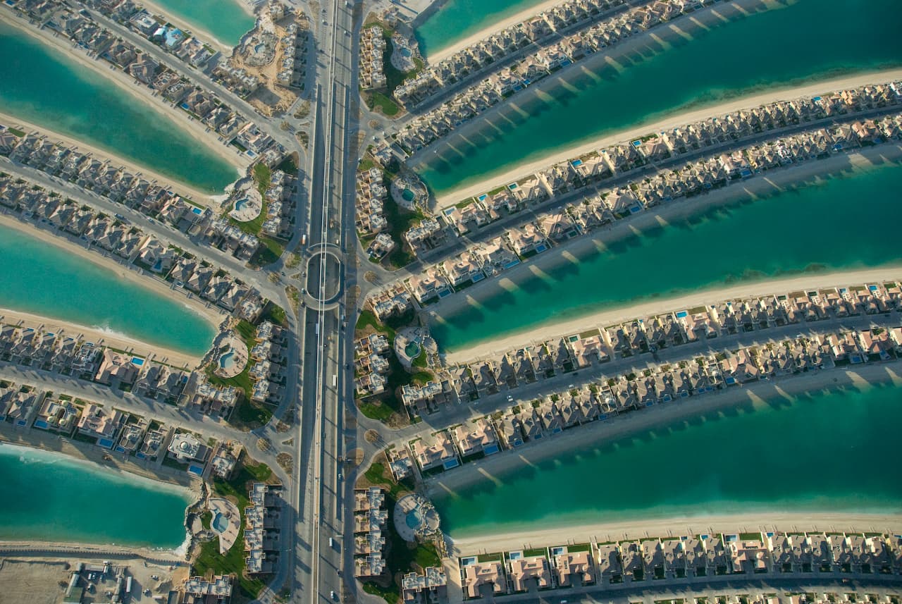 Aerial view of Palm Jumeirah's fronds, villa-lined streets and turquoise canals radiating from the trunk road